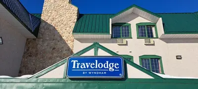 a sign for a travelodge store in front of a building at Travelodge by Wyndham Lacombe in Lacombe