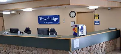 a travelodge counter with a sign on the wall at Travelodge by Wyndham Lacombe in Lacombe