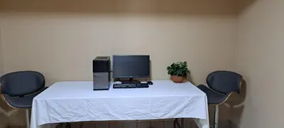 a desk with a computer on it with two chairs at Travelodge by Wyndham Lacombe in Lacombe