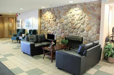 a lobby with couches and a stone wall at Travelodge by Wyndham Lacombe in Lacombe