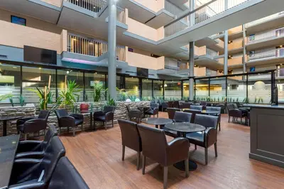 a restaurant with tables and chairs in a building at Best Western Plus Village Park Inn in Calgary