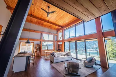 a living room with a large amount of windows at Luxe Modern Timberframe - Iconic Panorama Views with AC in Nelson