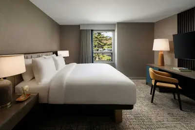 a hotel room with a large white bed and a desk at Kananaskis Mountain Lodge, Autograph Collection in Kananaskis Village