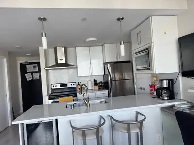 a kitchen with white cabinets and stainless steel appliances at Beautiful Bright with water view AC DT 2BR 2BTh 3BD sleeps 6 guests in Vancouver