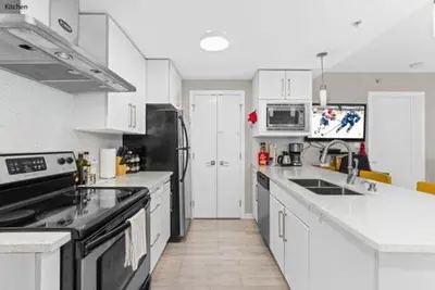a kitchen with white cabinets and black appliances at Beautiful Bright with water view AC DT 2BR 2BTh 3BD sleeps 6 guests in Vancouver
