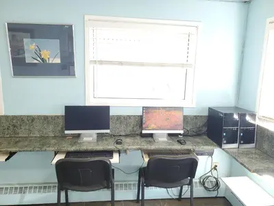 a desk with two computer monitors and two chairs at Stars Inn - Motel in Fort Saskatchewan