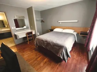 a hotel room with a large bed and a mirror at Stars Inn - Motel in Fort Saskatchewan