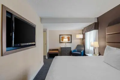 a hotel room with a bed and a flat screen tv at Best Western Premier Chateau Granville Hotel & Suites & Conference Centre in Vancouver