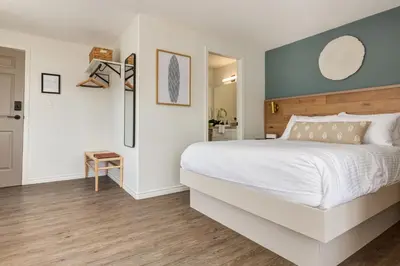 a bedroom with a white bed and a blue wall at Manana Resort and Marina in Ladysmith