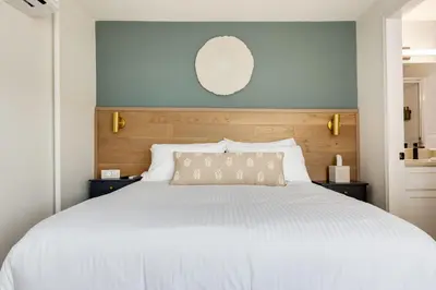a bedroom with a large white bed and a mirror at Manana Resort and Marina in Ladysmith