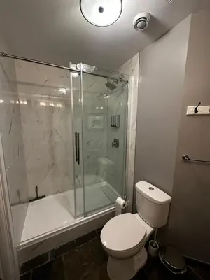 a bathroom with a shower and a toilet and a tub at Luxury Two Queen Beds Condo - Grande Rockies Resort Indoor Parking Pool Hot tub GYM in Canmore