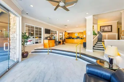 a living room with a ceiling fan and a lobby at Quality Inn Downtown Inner Harbour in Victoria