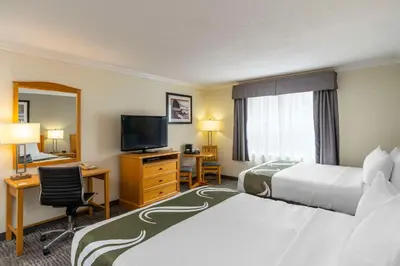 a hotel room with two beds and a flat screen tv at Quality Inn Downtown Inner Harbour in Victoria