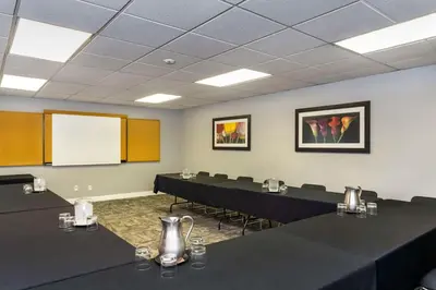 a conference room with black tables and a white screen at Quality Inn Downtown Inner Harbour in Victoria