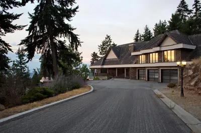 a house with a gambrel roof on a driveway at Honeymoon Suite in West Kelowna