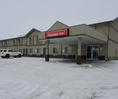 a building with a market inn sign in a parking lot at Westlake Inn in Strathmore