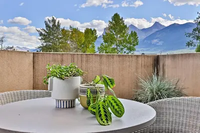 a table with two vases and plants on a patio at Ravens Crest Lodge - Stunning Views Perfectly Located on Main Street in Canmore