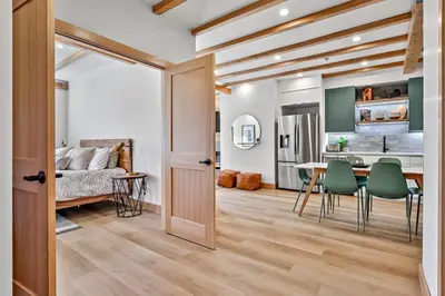 a kitchen and living room with a table and chairs at Ravens Crest Lodge - Stunning Views Perfectly Located on Main Street in Canmore