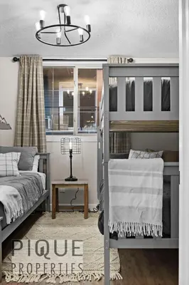a bedroom with two bunk beds and a lamp at Mystic Mountain Chalet, Heated Outdoor Pool & Hot Tub, Free Parking, Fast Wifi! in Canmore