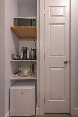 a kitchen with a white door and a microwave at Hotel Room in Windtower Lodge-121 in Canmore