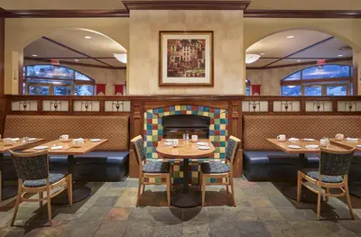 a restaurant with tables and chairs and a fireplace at Sun Peaks Grand Hotel & Conference Centre in Sun Peaks