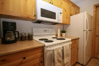 a kitchen with a white stove and a microwave at 2BR in Crystal Forest, Ski In, Ski Out, Fireplace, Private Hot Tub, Steps to the Village in Sun Peaks