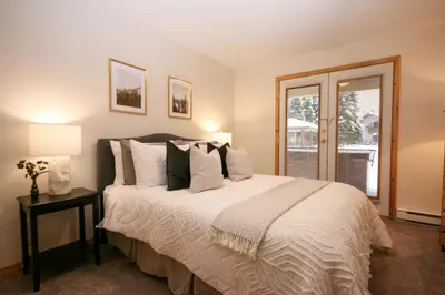 a bedroom with a large bed and a window at 2BR in Crystal Forest, Ski In, Ski Out, Fireplace, Private Hot Tub, Steps to the Village in Sun Peaks