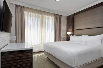 a bedroom with a large white bed and a television at Delta Hotels by Marriott Edmonton Centre Suites in Edmonton