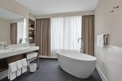 a bathroom with a large white tub and a sink at Delta Hotels by Marriott Edmonton Centre Suites in Edmonton