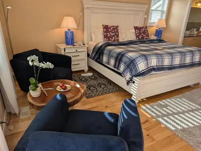 a bedroom with a bed and two chairs and a table at Salish B&B and Spa in West Kelowna