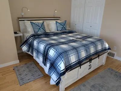 a bedroom with a bed with a blue and white comforter at Salish B&B and Spa in West Kelowna
