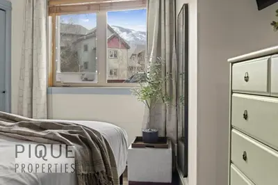 a bedroom with a bed and a window at Alpine Loft with Pool, Hot Tub & Mountain Views in Canmore