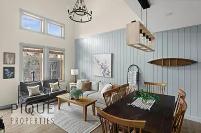a living room with a couch and a table at Alpine Loft with Pool, Hot Tub & Mountain Views in Canmore
