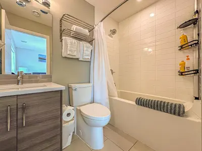 a bathroom with a toilet and a tub and a sink at Skyline Getaway - Mountain Views - Pool - Hot Tub in Canmore