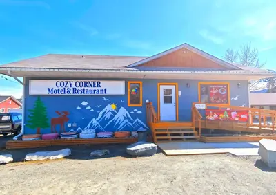 a small house with a sign on the side of it at Cozy Corner Motel & Restaurant in Haines Junction
