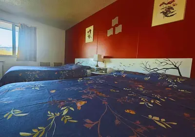 a bedroom with two beds with a blue comforter at Cozy Corner Motel & Restaurant in Haines Junction