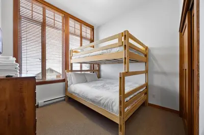 a bedroom with a bunk bed and a window at Settlers Crossing #29 By Bear Country in Sun Peaks