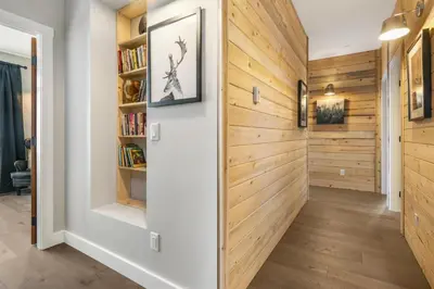 a hallway with wood paneling and a book shelf at Chalet Monashee - Brand New High-End Property with Amazing Views in Big White