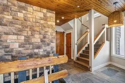a lobby with a stone wall and a bench at Chalet Monashee - Brand New High-End Property with Amazing Views in Big White