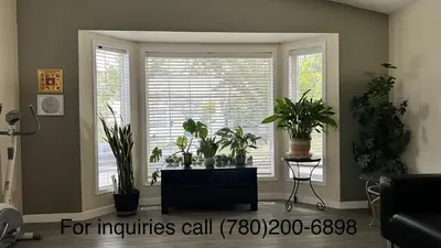 a living room with a window with plants in it at Private Rooms in a 3 Bedroom Guest House Close to Londonderry Mall 1 Person per Room No Couples For Men Only in Edmonton