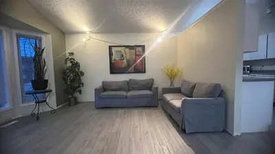 a living room with two chairs and a couch at Private Rooms in a 3 Bedroom Guest House Close to Londonderry Mall 1 Person per Room No Couples For Men Only in Edmonton