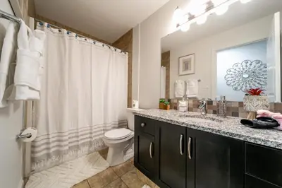a bathroom with a sink and a toilet and a shower at Mediterranean Retreat - King Bed - Fireplace - Garage in Edmonton