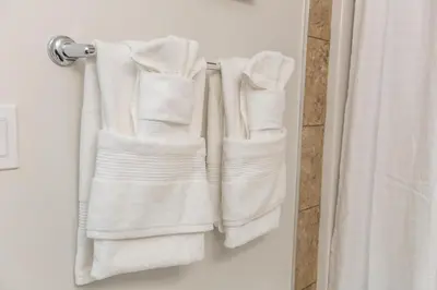 three towels hanging on a towel rack in a bathroom at Mediterranean Retreat - King Bed - Fireplace - Garage in Edmonton