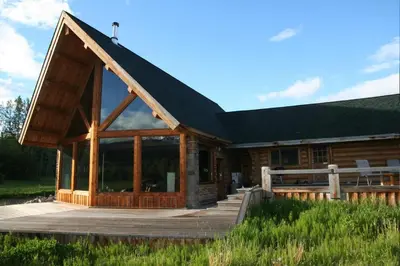 a log cabin with a porch and a deck at LDR Lodge - Last Dollar Ranch in Smithers