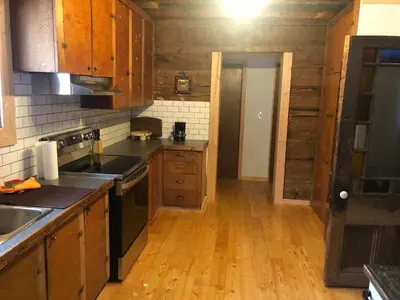 a kitchen with wooden cabinets and a wooden floor at Mini-Mooh cabin in Clearwater