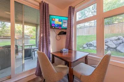 a dining room with a table and chairs and a window at 4 Bedrooms Suite Combo for Group of Families - Windtower Lodge in Canmore