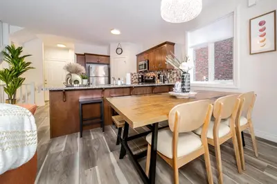 a kitchen and dining room with a wooden table and chairs at Bali Style Home - King Bed - Fireplace - Jacuzzi - Fast Wi-Fi - Free Netflix & Garage Parking in Edmonton