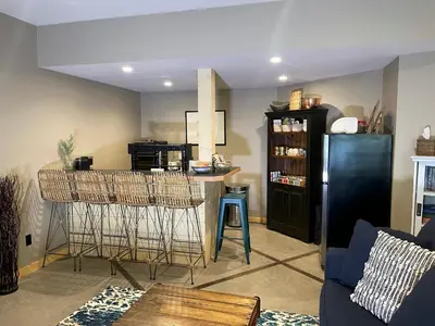 a living room with a kitchen with a bar with stools at Blanchard Mountain BnB in Canmore