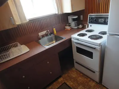 a kitchen with a white stove and a sink at Airport Inn in Quesnel
