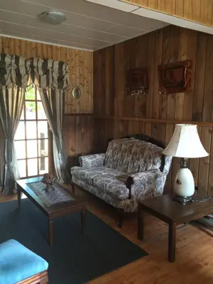 a living room with a couch and a table at Old Towne Inne Chuckwagon Bar & Grill in Boston Bar